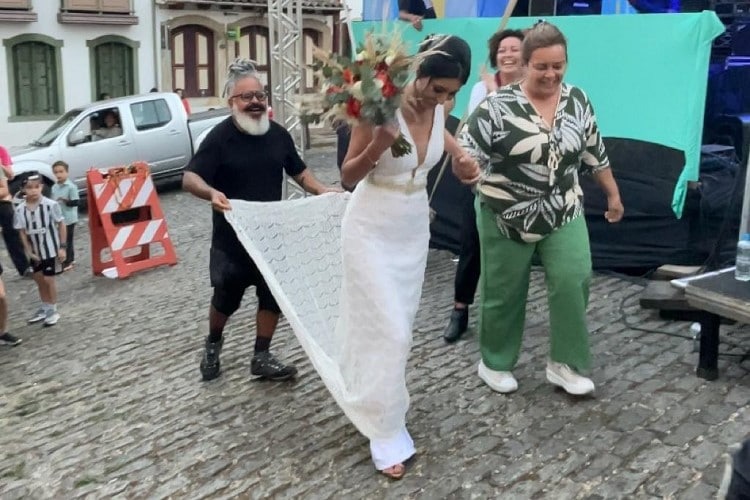 Noiva desfila pelo público de festival para chegar até seu casamento, em Ouro Preto