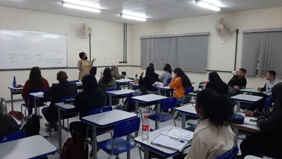 Sala de aula do cursinho pré-vestibular Premar, no Uaitec, em Mariana, Minas Gerais. Professora diante de quadro branco, explicando a alunos, em suas carteiras, detalhes sobre redação.