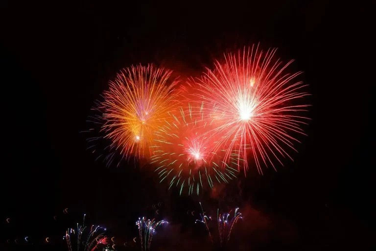 Fogos de artifício de diferentes cores sendo queimados no céu durante a noite