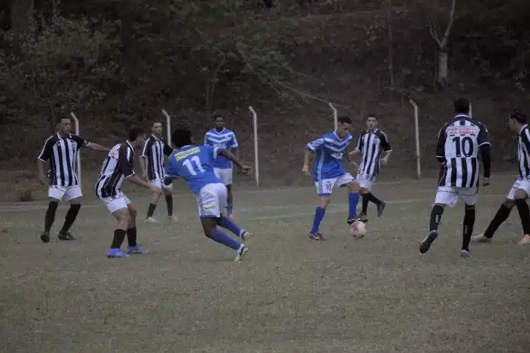 Jogadores do São Caetanense e União, os primeiros com calções brancos e camisas azuis, os da segunda equipe também com calções brancos e camisas em preto e branco, em partida da fase de grupos, que vai se repetir para decidir o Campeonato de Juniores.