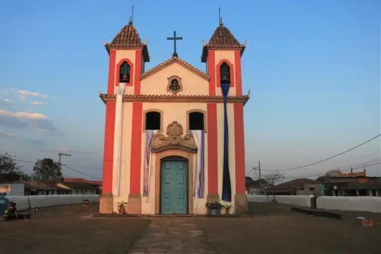 Fachada da Igreja Nossa Senhora dos Prazeres, decorada com fitas brancas e roxas, no centro do distrito de Lavras Novas, incluída no plano de tombamento provisório