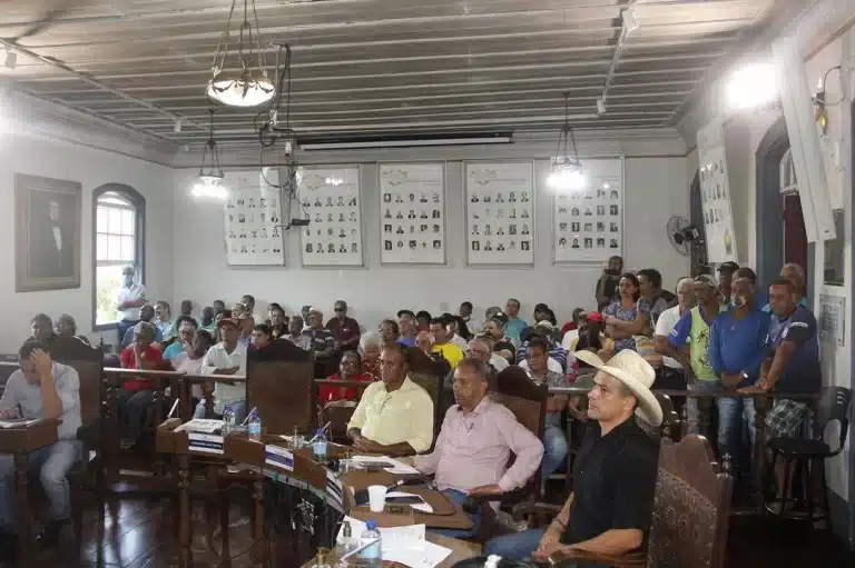 Em primeiro plano, alguns vereadores durante sessão da Câmara de Ouro Preto, que manteve o trancamento da pauta. Ao fundo, grande número de populares, alguns em pé, ocupando todo o espaço disponível para a plateia.