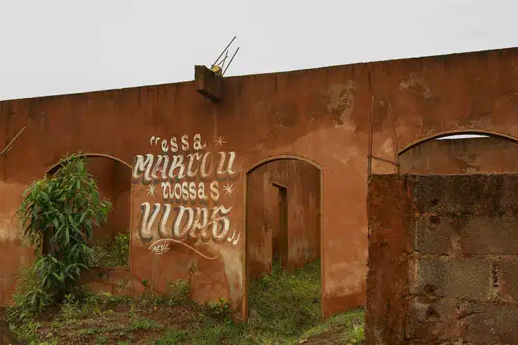 Ruína da Escola de Bento Rodrigues, com marcas da lama decorrente do rompimento da barragem de Fundão, com a inscrição "Essa marcou nossas vidas"