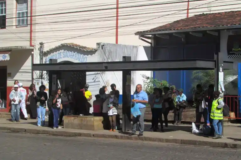 Usuários de transporte público municipal aguardam embarque em ponto de ôníbus situao na Praça Tancredo Neves (Terminal Turístico)